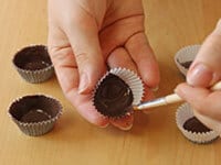 Using the small brush to spread the chocolate inside the case